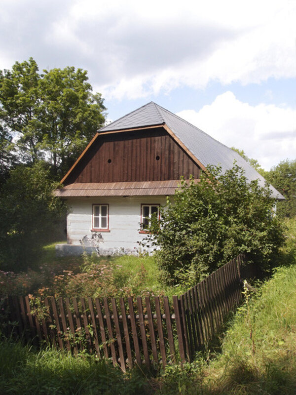 Pro objekt někdejší jednotřídky v Možděnicích je charakteristická sedlová střecha s polovalbou nad průčelím.