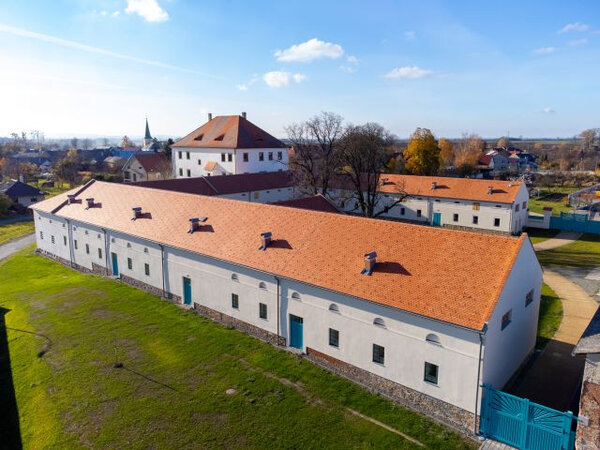 Hospodářský dvůr rozsvítily nové fasády i střechy s Bobrovkami Tondach.